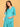 Turquoise Temptation Maternity Wrap Dress angled close-up with model touching hair, highlighting wrap neckline and comfortable fit.