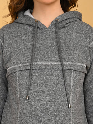 Close-up of grey maternity hoodie dress featuring drawstring hood and contrast seam detailing.