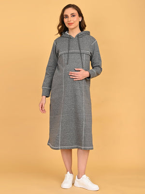 Pregnant model standing comfortably in grey maternity hoodie dress with relaxed knee-length silhouette.
