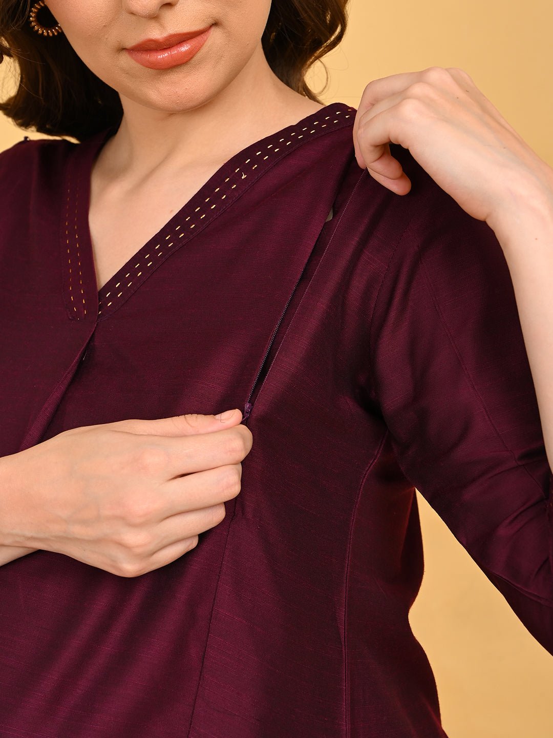 Close-up of concealed side zipper on wine maternity and nursing silk kurta for easy feeding access.