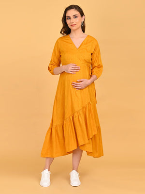 Heavily pregnant model posing with her hand over bump, yellow go go maternity wrap dress