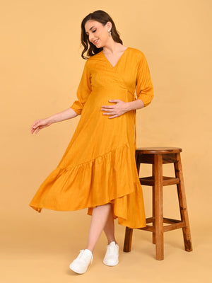 playful pose with model looking down in yellow go go maternity wrap dress